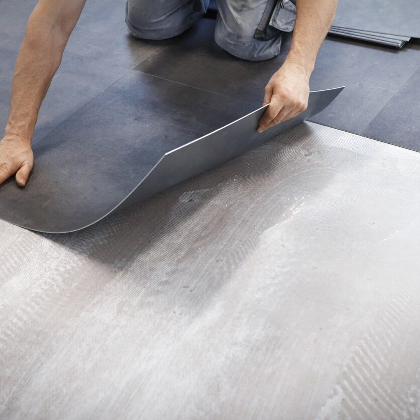 Worker making flooring with vinyl tiles